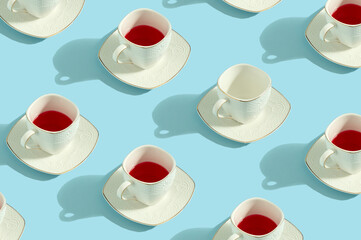 Pattern of white cups with red drink and one empty. Retro coffee cups on pastel blue background.