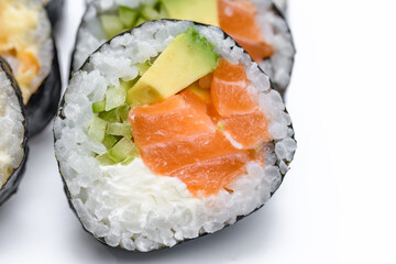 Zbliżenie na liściach i inne składniki sushi zawiniętego w algi nori,  ujęcie makro  - obrazy, fototapety, plakaty