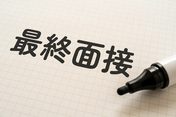 最終面接と書かれたノートとマーカー