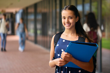 Portrait Of Female Secondary Or High School Student Outdoors At School Walking To Class