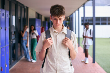 Unhappy Teenage Boy Outdoors At High School Being Teased Or Bullied