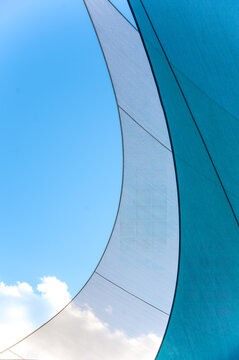 Sailboat sails abstract against a bright blue sky. Photography