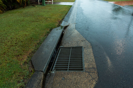stormwater drain and reflections on a wet road