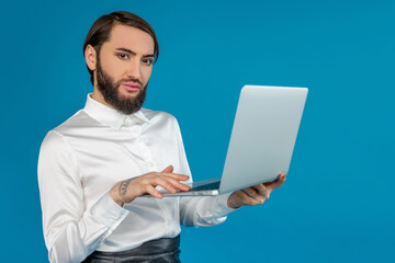 Attractive self confident transgender man office worker wearing white shirt working on notebook