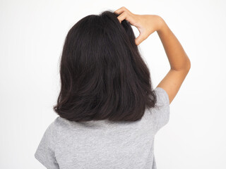 Little girl is scratching her head on white background. Closeup photo, blurred.