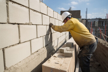 Gros plan sur un ma&ccedil;on travaillant sur un mur de briques &raquo; IA g&eacute;n&eacute;rative