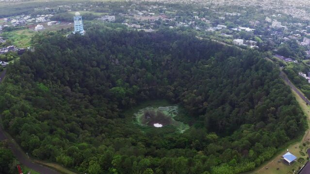 Flying drone 4K video over Trou aux Cerfs dormant volcano crater covered exotic trees and plants. Mauritius island losted in Indian ocean.