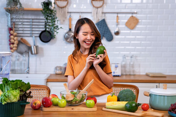 Beautiful young woman happy portrait cooking fresh organic clean food fruit at home modern kitchen