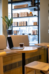 Black coffee and a portable computer on the cafe table