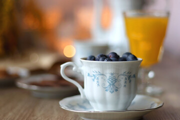 Cup of tea or coffee, plate of cookies, cup of blueberries, plate of chocolate, glass of juice,...