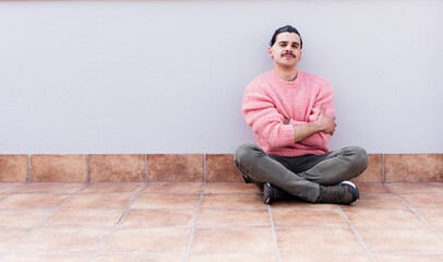 young handsome man sitting on the floors with a copyspace