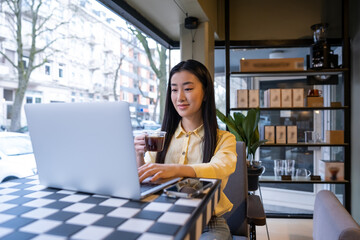 Focused female freelancer working on the computer in a cafe