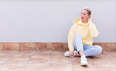 pretty caucasian sitting  woman looking serious and curious, listening, trying to hear a secret...