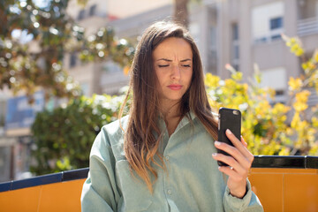 pretty woman smiling and looking with a happy confident expression. smartphone concept