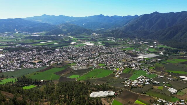 Aerial view of the Constanza town in a valley surrounded by mountains. Agriculture of Dominican Republic, high production of vegetables and fruits