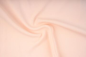 The texture of the satin fabric of beige color for the background