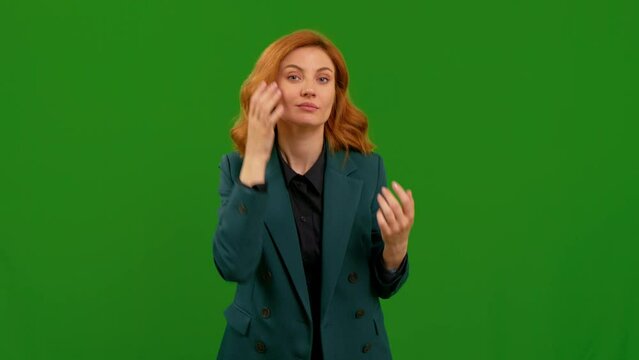 Woman touching her hair while looking at camera like mirror on Green Screen background studio. Female getting ready for date.