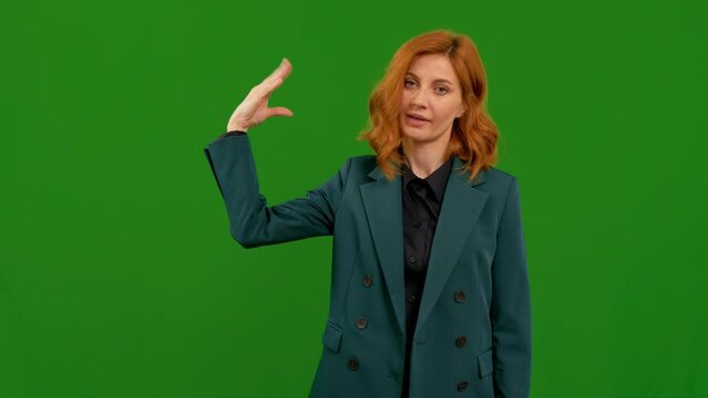 Portrait of young woman doing bla-bla-bla gesture while standing in front of the camera on the chroma key background. Bored female by a non- productive conversation.