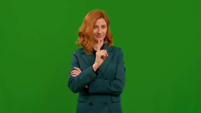 Young woman pointing finger scold at someone or warn gesture. Teacher asks students to behave over green screen background. Gesture concept.