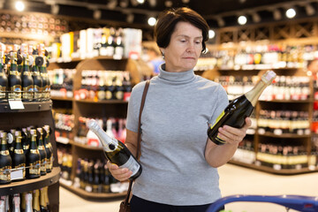 Elderly woman choose bottle of champagne