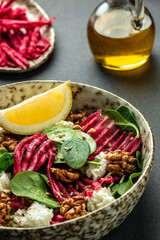 Fototapeta na wymiar Vegetable salad of beet, baby spinach, nuts and cheese. vertical image. top view. place for text