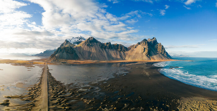 Aerial panorama of Vestrahorn Mountain in Stokksnes peninsula in Iceland during sunset with reflections. Amazing natural scenery of Iceland. Popular tourist attraction. 