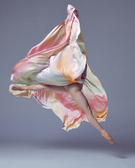 Fototapeta na wymiar Ballerina wearing colorful dress dancing elegant movements with fabric over grey studio background. Showing flexibility and grace