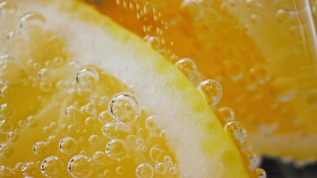 Bubbly Drink and Lemon Slices in Glass Cup Close Up. Making Sour Alcoholic Cocktail of Vodka or White Rum at Home on Studio Shot in Macro. Drinking Sparkling Water as Detox Fluid or Pure Mineral Aqua