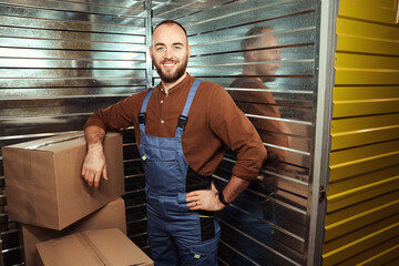 Pleased young male standing leaning on a box