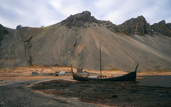 Abandoned viking village in Stokksnes, Iceland. The replica of the Viking houses and boats on the shore gives us a glimpse of how the Vikings used to live in the past.