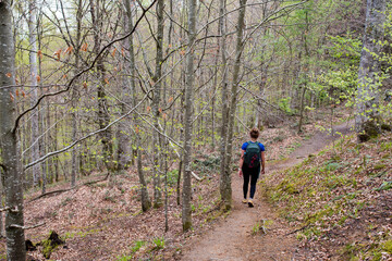 Obraz premium Pretty young woman in sportswear doing a trail in the mountains near the Holtzate Gorge