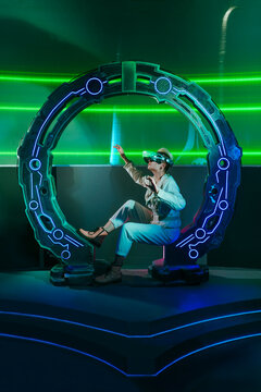 Young woman wearing virtual reality simulators sitting in futuristic circle