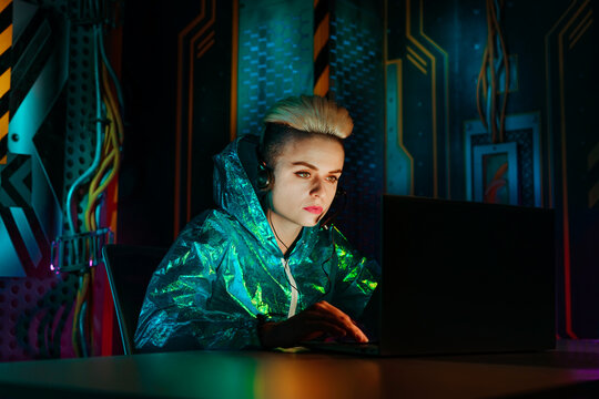 Gamer wearing headset playing video games on laptop at desk