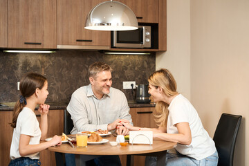 Happy family time together at breakfast in kitchen in hotel room