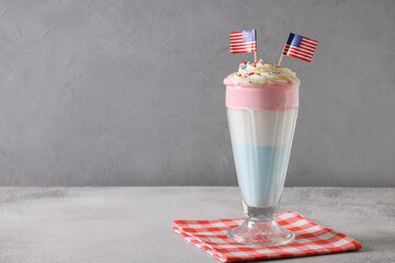 Patriotic milkshake with American flag, whipped cream, red, white and blue sprinkles as stars for...