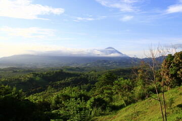 The appearance of mountain peaks in the distance with hills in the foreground.