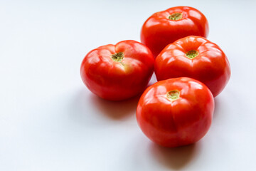 bunch of red tomatoes close up on white background