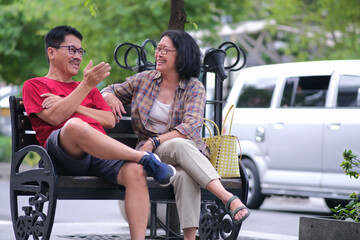 Obraz premium Man and woman casually sitting on a park bench and chatting at Malioboro street