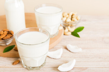 Set or collection of various vegan milk almond, coconut, cashew, on table background. Vegan plant based milk and ingredients, top view