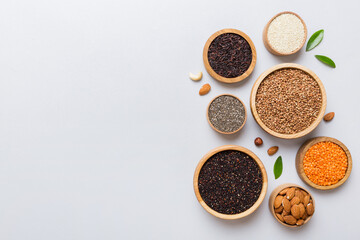 Various superfoods in smal bowl on colored background. Superfood as rice, chia, quinoa, lentils, nuts, sesame seeds, almonds. top view copy space