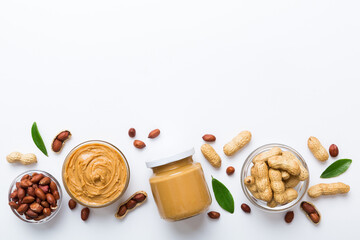 Bowl of peanut butter and peanuts on table background. top view with copy space. Creamy peanut pasta in small bowl