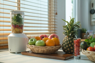 Blender, fresh tropical fruit and vegetable on wooden table for making healthy smoothie. Detox, healthy, vegan food, dieting concept.