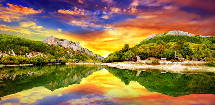 Dramatic sunset over a picturesque mountain lake in the Bakhchisaray region of Crimea near the ancient fortress city of Mangup-Kale. Mangup, Crimea, Ukraine