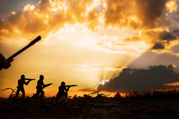 war concept, toy military soldiers on the battlefield at sunset