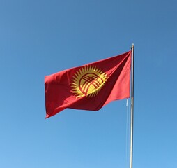 The Kyrgyz republic red and yellow flag wawing blue sky