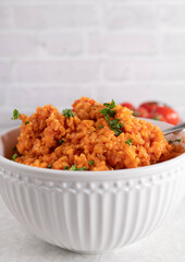 Greek tomato brown rice in a white bowl isolated on light background