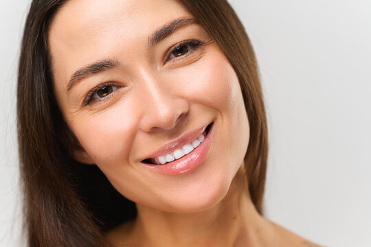 Portrait view of the beautiful asian woman smiling toothy while standing at the isolated white background. Stock photo