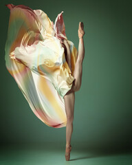 One young professional ballet dancer, girl wearing rainbow dress dancing over dark green studio background. Perfect body flexibility © Lustre Art Group 
