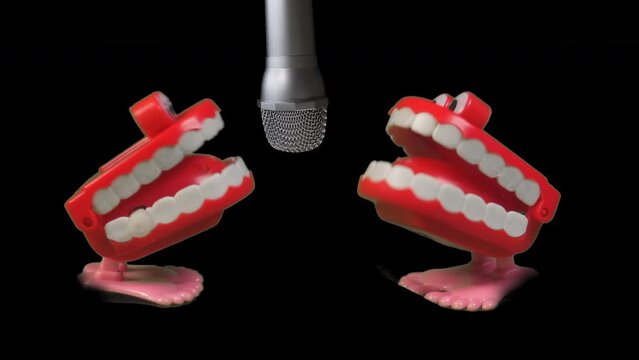Two fun toy joke sets of chatty teeth chattering or singing into  a microphone in slow motion. Broadcasting chat or singing a duette.
