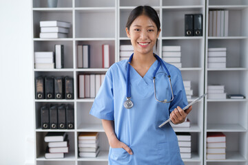 Portrait of young smart medical student smiling to the camera while holding tablet in her hand.